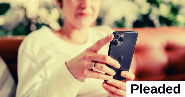 A woman holds and looks at a cellphone