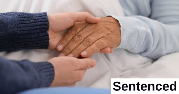 A younger person holds and older person's hand.