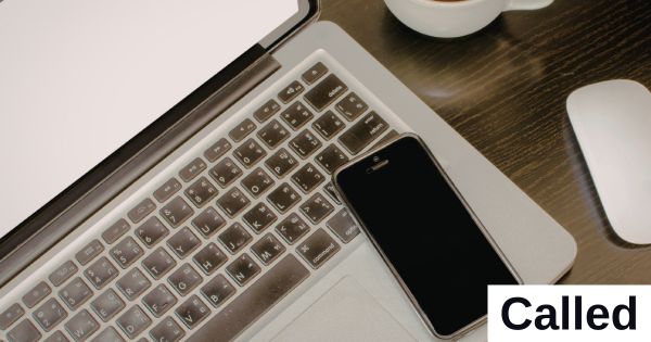 A mobile phone sits on the keyboard of a laptop.