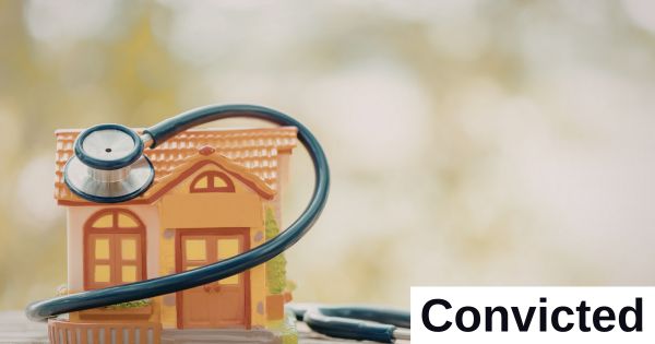 A stethoscope sits around a statue of a home.