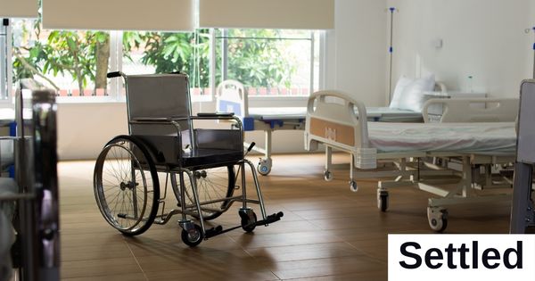 An empty room with a medical bed and a wheelchair.